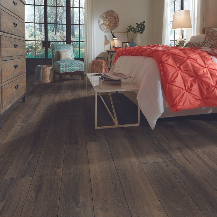 Luxury Vinyl Flooring in Bedroom. Bed, side table, chair, and window